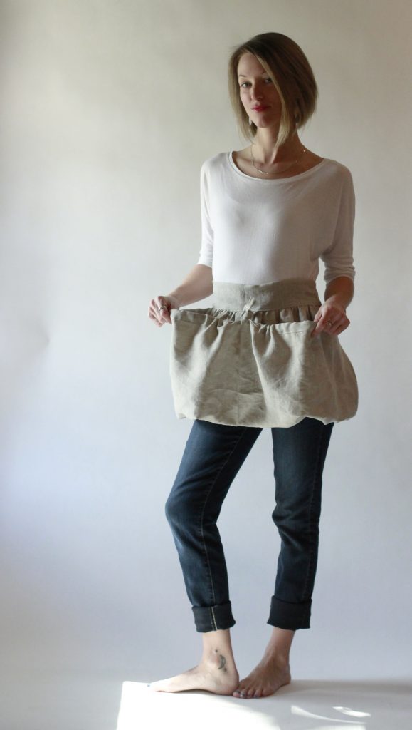 Oatmeal Linen Gathering Apron with its drawstring allowing the apron to be shaped into two large pockets.